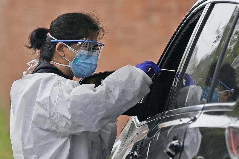 Medical personnel prepare to administer a COVID-19 swab at a drive-through testing site in Lawrence, N.Y., Wednesday, Oct. 21, 2020. (AP Photo/Seth Wenig)


