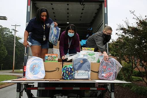 Amazon employees unpack a truck filled with school supplies at Bess T. Shepherd Elementary School. From left, are Monique Geter, Ashley Webb-Grabe and Jessica Bramlett.