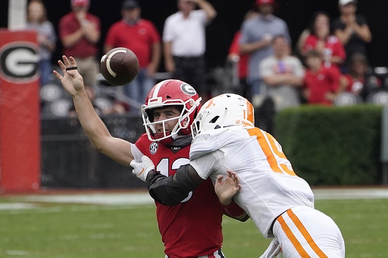 Georgia quarterback Stetson Bennett (13) is hit by Tennessee linebacker Morven Joseph (19) as he releases a pass in the first half of an NCAA college football game Saturday, Oct. 10, 2020, in Athens, Ga. (AP Photo/John Bazemore)