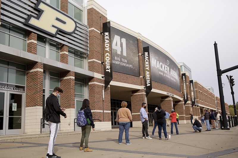 FILE - In this Oct. 14,l 2020, file photo, voters line up outside Purdue University's Mackey Arena for early voting ahead of the 2020 general election, in West Lafayette, Ind. The Tippecanoe County Board of Elections used Mackey Arena as a satellite polling location Wednesday. NFL, NBA, NHL, Major League Baseball, Major League Soccer and college venues are serving various roles in unprecedented ways, including providing space for people to vote while social distancing on Election Day. (Nikos Frazier/Journal & Courier via AP)