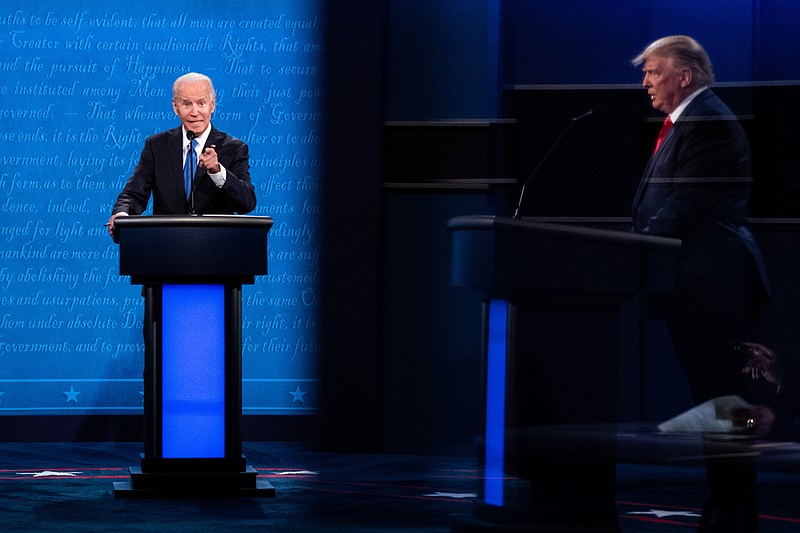 New York Times photo by Erin Schaff/Joe Biden and President Donald Trump, seen in reflection, participate in the final presidential debate, at Belmont University in Nashville on Thursday.