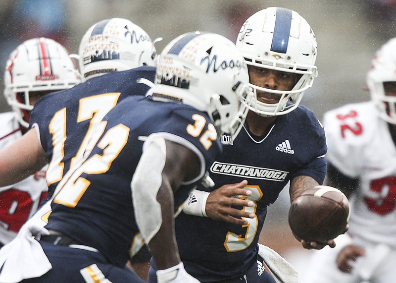 Staff photo by Troy Stolt / UTC quarterback Drayton Arnold hands off to Ailym Ford during the first half of Saturday's game at Western Kentucky in Bowling Green. Ford rushed for 92 yards on 25 carries and Arnold had a touchdown run in the Mocs' 17-13 loss in a game not decided until the final minutes.