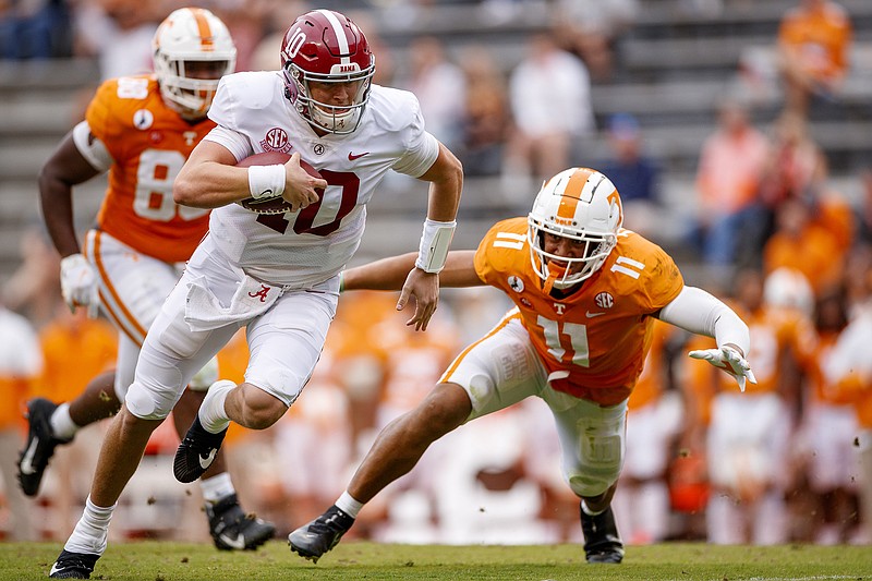 Tennessee Athletics photo by Kate Luffman / Alabama quarterback Mac Jones sprints away from Tennessee linebacker Henry To'o To'o (11) during Saturday's game in Knoxville. Jones was 25-of-31 passing for 387 yards to lead the second-ranked Crimson Tide to a 48-17 victory at Neyland Stadium, handing the Vols their 14th straight loss in the border rivalry.