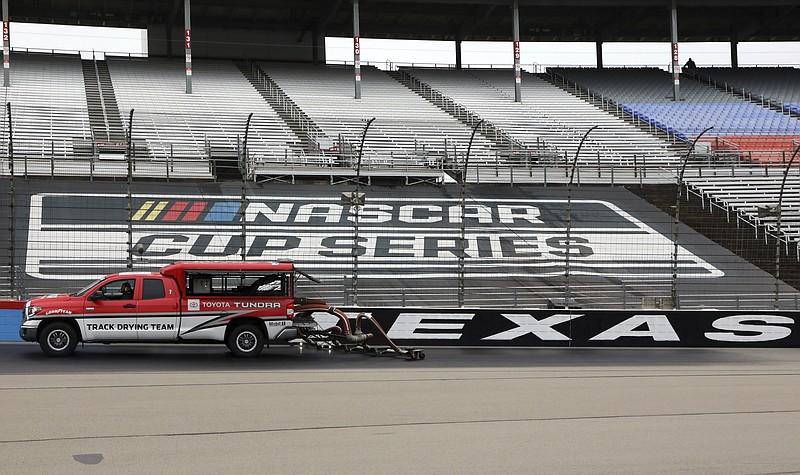 Drying trucks continue to dry the track in an attempt to get it ready for a NASCAR Cup Series auto race after morning rain prevented the 9 a.m. rescheduled start at Texas Motor Speedway in Fort Worth, Texas, Monday, Oct. 26, 2020. (AP Photo/Richard W. Rodriguez)