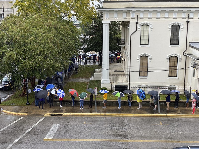 People wait in the rain to vote in Montgomery, Ala., on Saturday, Oct. 24, 2020. Alabama Secretary of State John Merrill said a record number of absentee ballots have already been cast this year in the election. Some counties allowed Saturday voting for the first time. (AP Photo/Kim Chandler)