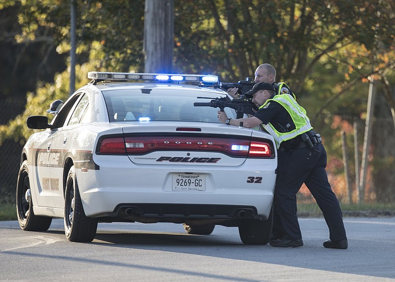 Staff photo by Troy Stolt / East Ridge police officers take cover after several shots were fired near Lake Winnepesaukah Amusement Park on Sunday, Oct. 18, 2020 in Rossville, Georgia.