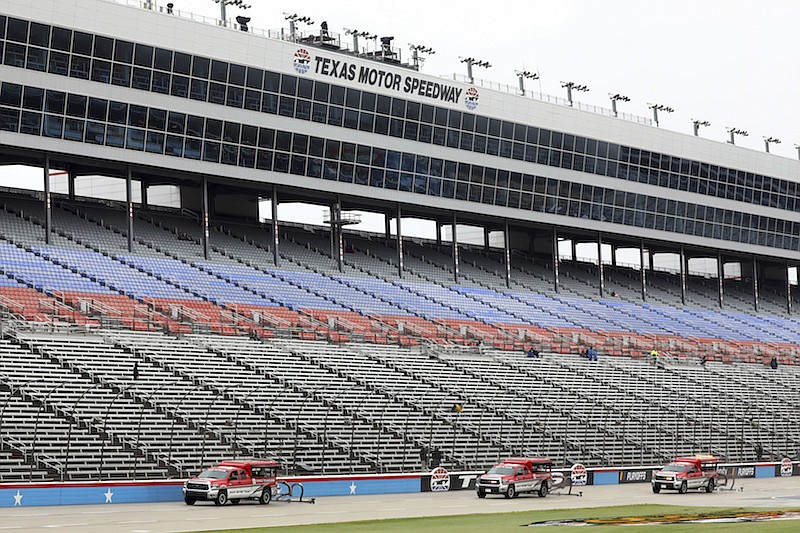Drying trucks continue to prepare the track for a possible NASCAR Cup Series auto race at Texas Motor Speedway in Fort Worth, Texas, Tuesday, Oct. 27, 2020. The race was stopped on Sunday because of drizzle and misty conditions that allowed drivers to complete just 52 of 334 laps. Another 115 laps have to be completed to get to the halfway mark of 167 laps that would make Texas an official race. (AP Photo/Richard W. Rodriguez)