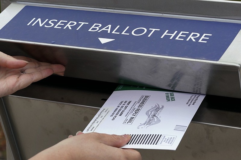 FILE - In this Thursday, Oct. 15, 2020, file photo, Nikki Schueller inserts her absentee voter ballot into a drop box in Troy, Mich. Just days before the presidential election, millions of mail-in ballots have still not been returned in key battleground states. Many of those are due in county offices by Tuesday, Nov. 3, but the latest Postal Service delivery data suggests it's too late for voters to drop their ballots in the mail. (AP Photo/Paul Sancya, File)


