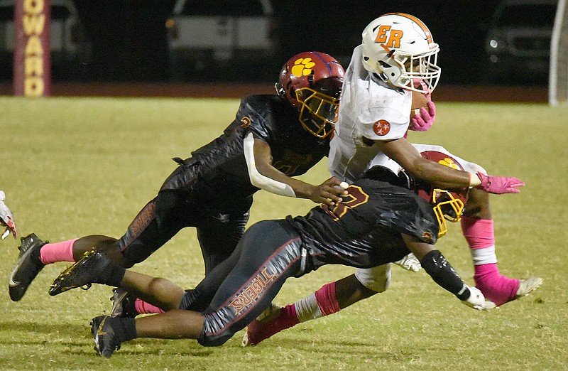 Howard's JaCobi Dixon, left, and Marcus Reed tackle East Ridge's Desmon Drake last Friday at Howard. The host Hustlin' Tigers won to run their streak of victories to four.