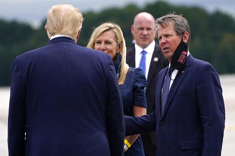 President Donald Trump greets Georgia Gov. Brian Kemp and his wife Marty as he arrives at Dobbins Air Reserve Base for a campaign event at the Cobb Galleria Centre, Friday, Sept. 25, 2020, in Atlanta. (AP Photo/Evan Vucci)