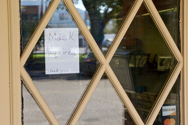 Staff photo by Wyatt Massey / A sign requiring masks is seen outside Simmons Jewelry in Jasper, Tennessee, on Oct. 30, 2020.