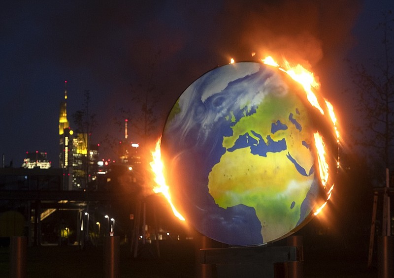 A makeshift globe burns in front of the European Central Bank in Frankfurt, Germany, Wednesday, Oct. 21, 2020. Activists of the so-called "KoalaKollektiv", an organization asking for climate justice, protested with the burning of the globe against the ECB's climate policy. (AP Photo/Michael Probst)