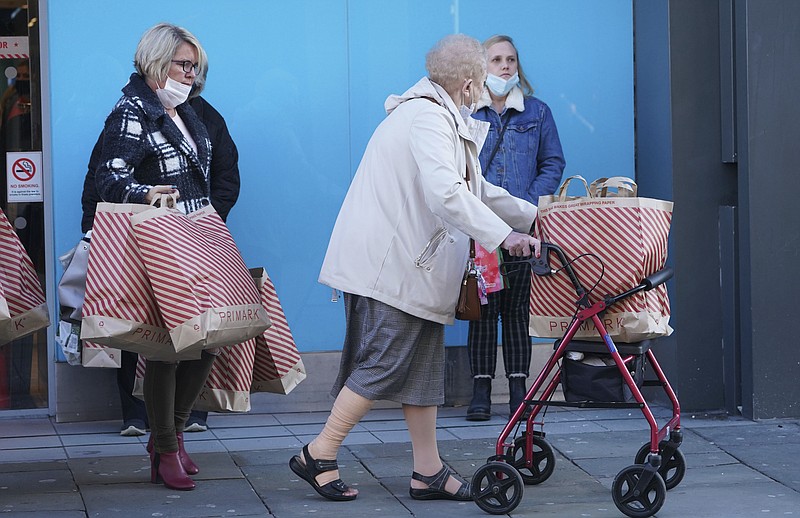 Shoppers leave a store in Northumberland Street, ahead of a national lockdown for England which begins on Thursday, in Newcastle, England, Wednesday, Nov. 4, 2020. A second lockdown in England is set to come into force on Thursday. It's a big blow to businesses that sweeps away any hopes that the British economy might have recovered by the end of this year a large proportion of the near 25% drop endured in the spring. (Owen Humphreys/PA via AP)


