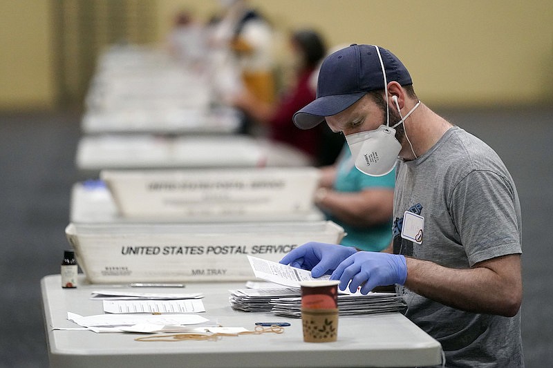Workers prepare mail-in ballots for counting, Wednesday, Nov. 4, 2020, at the convention center in Lancaster, Pa., following Tuesday's election. (AP Photo/Julio Cortez)