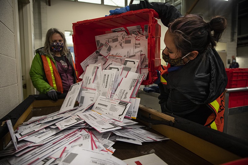 The Associated Press / Election worker Kristen Mun empties ballots from a ballot box at the Multnomah County Elections Division on Tuesday in Portland, Oregon.