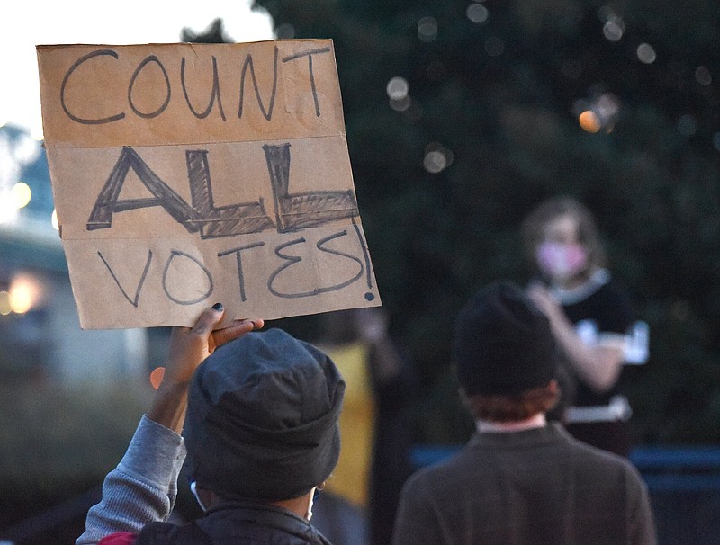 Staff Photo by Matt Hamilton / Chattanooga resident Chandra Ward holds a sign as Evelina Kertay speaks at Coolidge Park on Wednesday, Nov. 4, 2020. About 75 people gathered for the "Rally for Democracy." Kertay is the vice president of the Young Democratic Socialists of America at UTC.