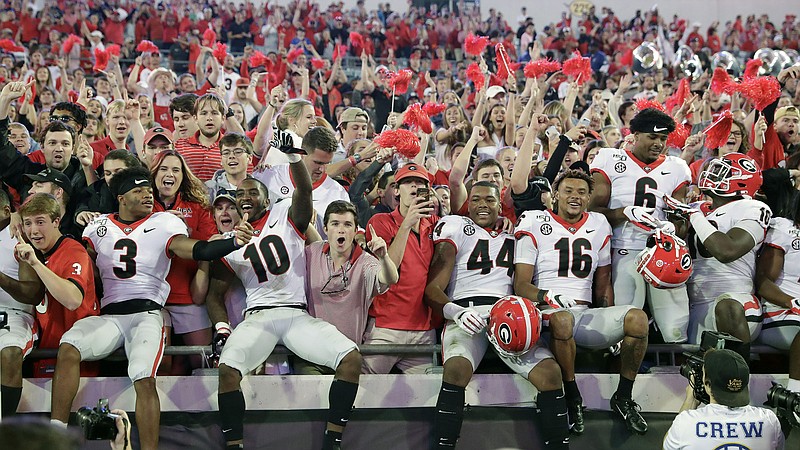 AP photo by John Raoux / Georgia football players celebrate with fans after last season's 24-17 win over Florida in Jacksonville.
