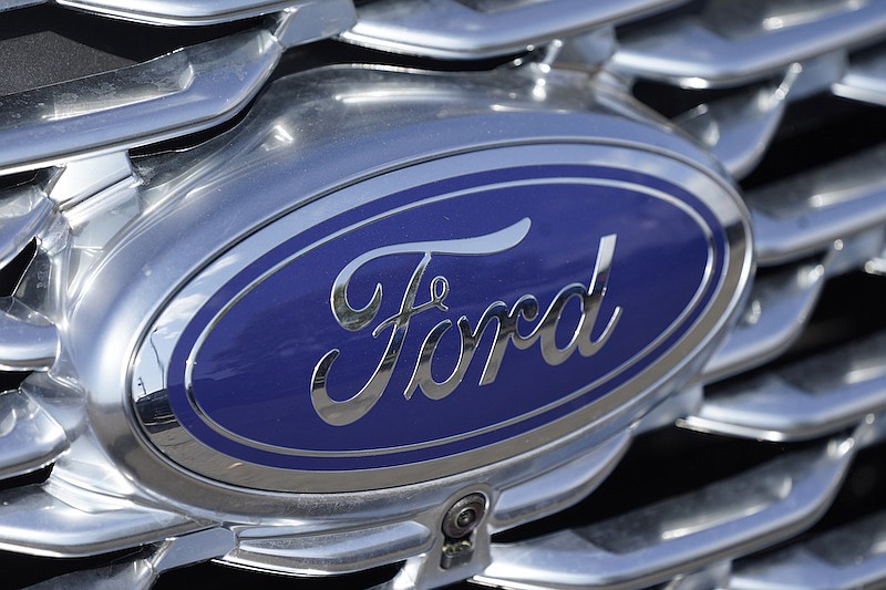 The company logo sparkles on the grille of an unsold 2020 Explorer sports-utility vehicle at a Ford dealership Sunday, Oct. 11, 2020, in Denver. (AP Photo/David Zalubowski)