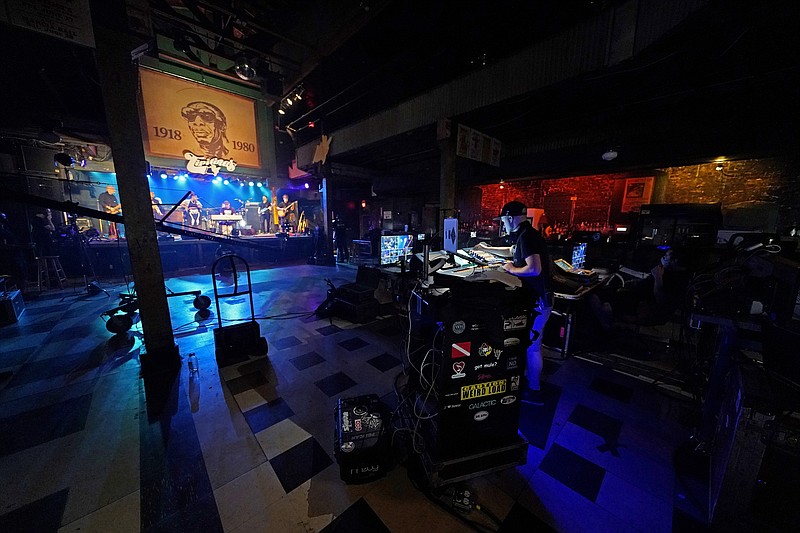 In this Oct. 26, 2020, photo, production engineers record the band Galactic for a video stream concert, inside an empty Tipitina's music club, which the band owns, in New Orleans. Music clubs all over the nation — pop culture icons like the Troubadour in West Hollywood, the Bluebird Cafe in Nashville, The Bitter End in New York's Greenwich Village — are shuttered due to the coronavirus. And owners fear for the future of their businesses and of a musical way of life. (AP Photo/Gerald Herbert)