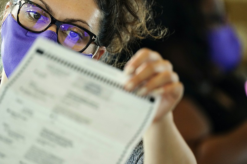 Associated Press photo by Brynn Anderson/An election worker counts ballots at State Farm Arena on Thursday in Atlanta.