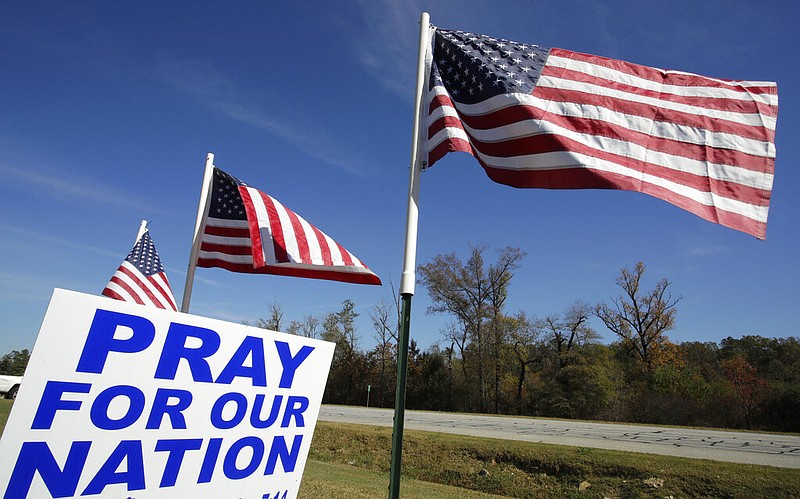 American flags fly over a sign reading 'Pray For Our Nation' on Highway 27 Friday, Nov. 6, 2020, in Rome, Ga. (AP Photo/Ben Margot)