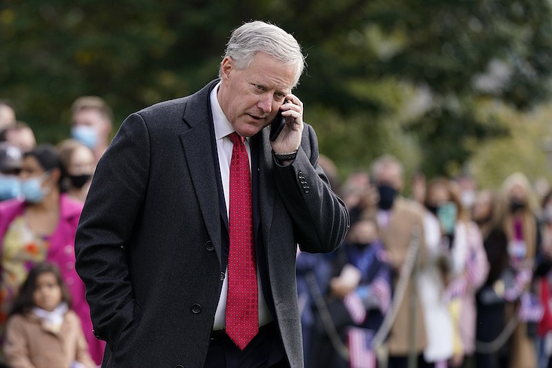 In this Oct. 30, 2020, photo, White House chief of staff Mark Meadows speaks on a phone on the South Lawn of the White House in Washington. Meadows has been diagnosed with coronavirus. (AP Photo/Patrick Semansky)