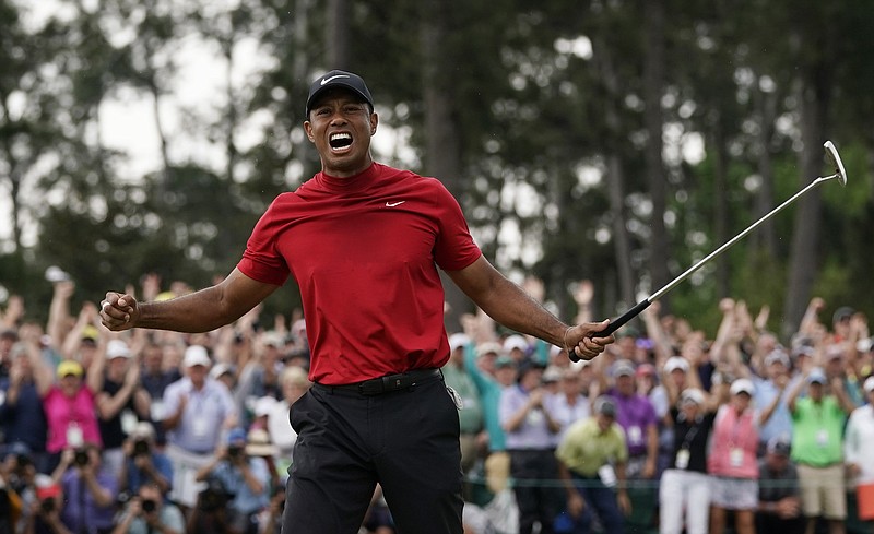 AP photo by David J. Phillip / Tiger Woods celebrates his Masters victory in April 2019 as fans cheer him on at Augusta National Golf Club. The Georgia course will be closed to spectators for this year's edition of the major championship, which tees off Thursday.