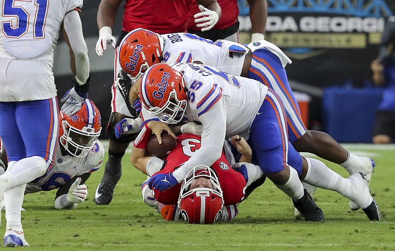 AP photo by Curtis Compton / Georgia quarterback Stetson Bennett is tackled at the line of scrimmage by Florida defensive lineman Kyree Campbell (55) during the first half on Saturday afternon in Jacksonville, Fla.