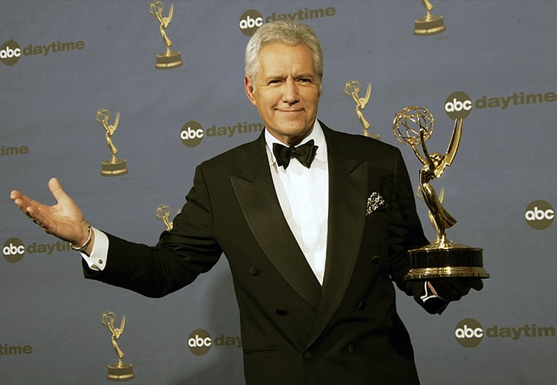 FILE - In this Friday, April 28, 2006, file photo, Alex Trebek holds the award for outstanding game show host, for his work on "Jeopardy!" backstage at the 33rd Annual Daytime Emmy Awards in Los Angeles. Jeopardy!" host Alex Trebek died Sunday, Nov. 8, 2020, after battling pancreatic cancer for nearly two years. Trebek died at home with family and friends surrounding him, "Jeopardy!" studio Sony said in a statement. Trebek presided over the beloved quiz show for more than 30 years. (AP Photo/Reed Saxon, File)