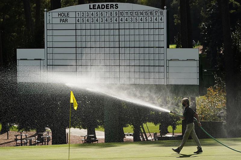 A course worker waters the third hole during a practice round for the Masters golf tournament Monday, Nov. 9, 2020, in Augusta, Ga. (AP Photo/Matt Slocum)