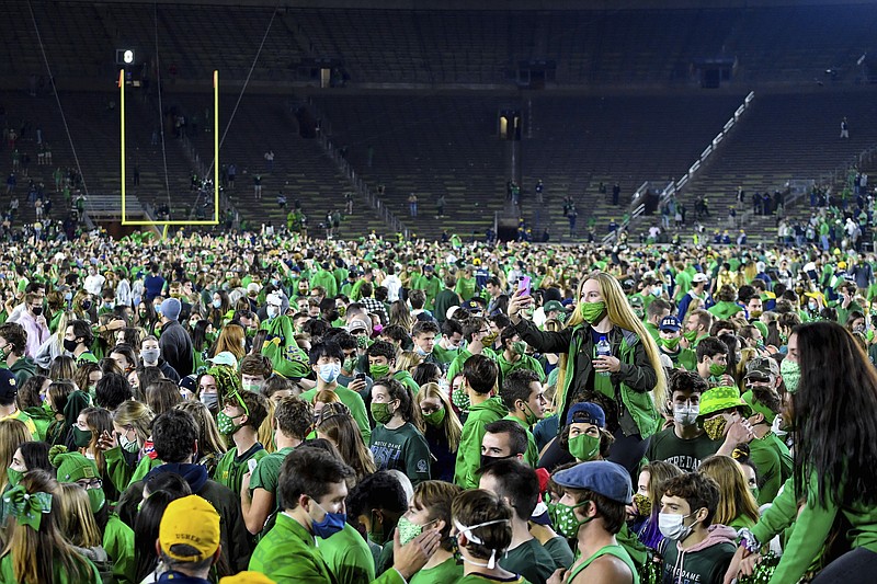 Fans storm the field after Notre Dame defeated the Clemson 47-40 in two overtimes in an NCAA college football game Saturday, Nov. 7, 2020, in South Bend, Ind. (Matt Cashore/Pool Photo via AP)