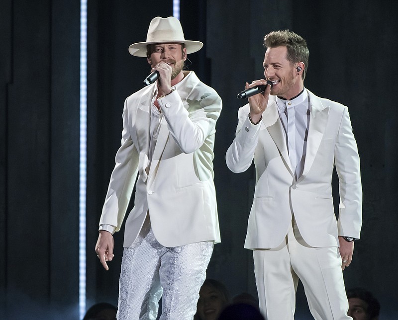 Brian Kelley, left, and Tyler Hubbard of Florida Georgia Line perform "Meant to Be" at the 52nd annual CMA Awards in Nashville, Tenn. on Nov. 14, 2018. Hubbard is the second artist so far that will miss a scheduled performance at the CMA Awards on Wednesday due to COVID-19. He posted a note on his Instagram page on Monday, Nov. 9, 2020, saying he was asymptomatic and quarantining on his bus outside his home. It comes days after another artist, Lee Brice, also revealed he had tested positive and would not perform on the show. (Photo by Charles Sykes/Invision/AP, File)