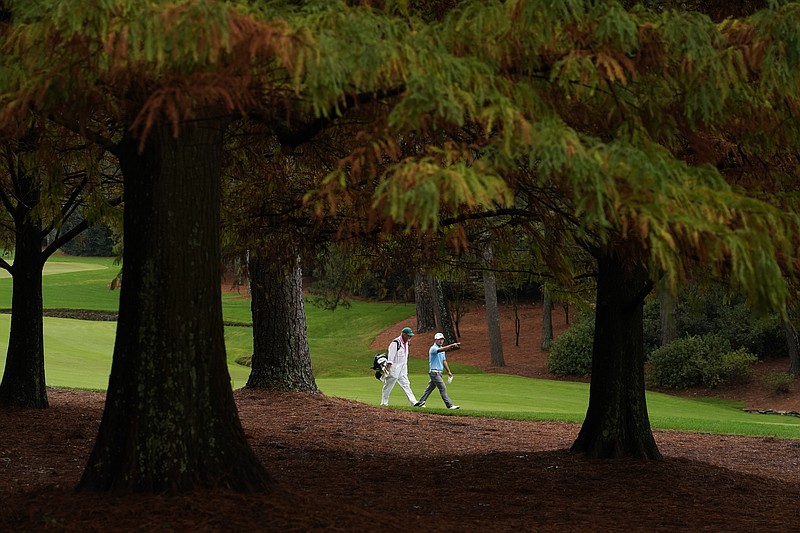 AP photo by Charlie Riedel / Sung Kang and his caddie walk the 13th fairway at Augusta National Golf Club on Wednesday during a practice round for the Masters.