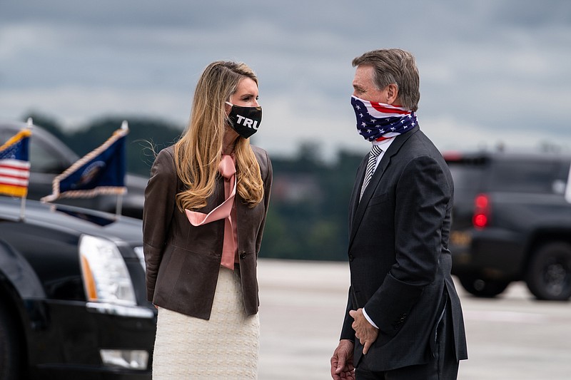 Photo by Anna Moneymaker of The New York Times / Georgia Republican Sens. Kelly Loeffler and David Perdue wait to greet President Donald Trump as he exits Air Force One in Atlanta on Sept. 25, 2020.