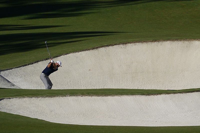 AP photo by David J. Phillip / Dustin Johnson hits out of a bunker on the eighth hole at Augusta National Golf Club during the second round of the Masters on Friday. The Georgia course is playing much different than usual after a rainy start in November instead of the major tournament's usual time slot of early April, but Johnson was one of four who shared the clubhouse lead Friday evening when play was suspended due to darkness.