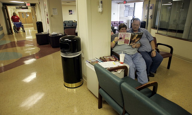 TennCare patient Cheryl Edwards reads a magazine while she and Darrell Edwards wait in the Baptist Hospital Emergency Room waiting room, Aug. 23, 2005, in Nashville, Tenn. (AP Photo/The Tennessean, Billy Kingsley)