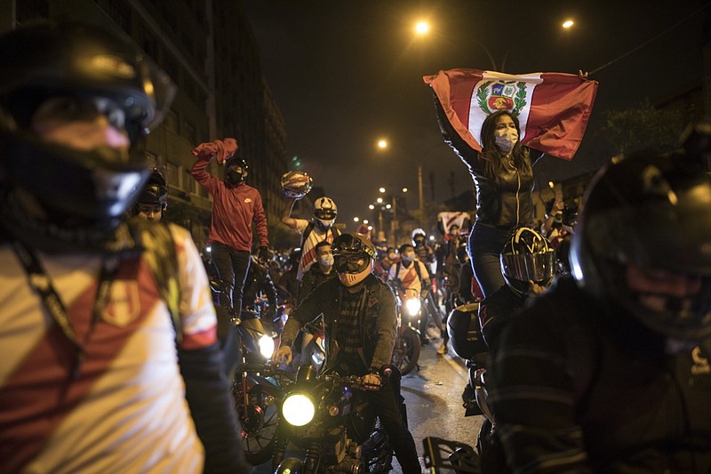 A caravan of demonstrators on motorcycles ride as they wait for news on who will be the country's next president, in Lima, Peru, Sunday, Nov. 15, 2020. Manuel Merino announced his resignation following massive protests, unleashed when lawmakers ousted President Martin Vizcarra. (AP Photo/Rodrigo Abd)