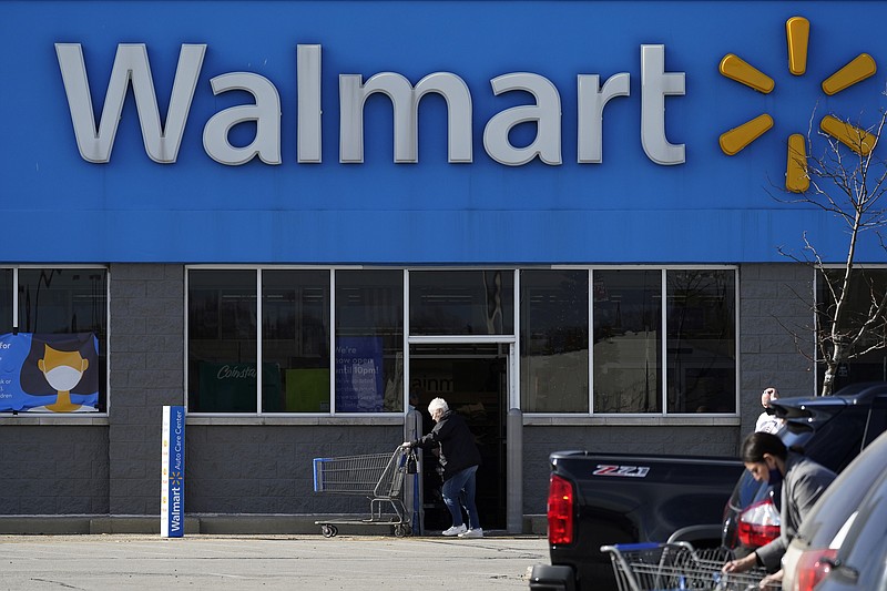 In this Nov. 5, 2020 file photo, a woman pushes a shopping cart to enter a Walmart in Rolling Meadows, Ill. Walmart turned out another stellar quarter as the world's largest retailer powers through a pandemic that has felled other national chains. The Bentonville, Arkansas-based retailer delivered a 56% increase in its fiscal third-quarter profits while revenue rose 5.3%. (AP Photo/Nam Y. Huh, File)