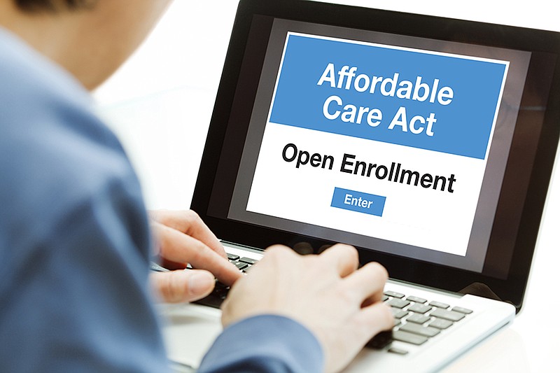 A man using a laptop computer and the internet web service, he is in the process of signing up and joining the Affordable Care Act Obamacare in the United States in the open enrollment for his healthcare insurance plan. Photographed close-up in a horizontal format.