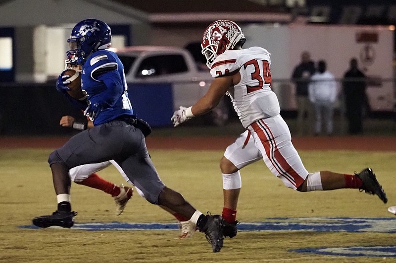 Staff photo by C.B. Schmelter / Red Bank's Lumiere Strickland runs away from a Loudon defender during Friday night's TSSAA Class 3A quarterfinal at Red Bank.