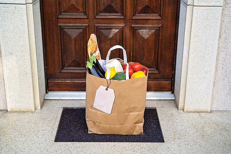 Getty Images / Contactless food delivery offers groceries brought to our house and left outside an entrance door.