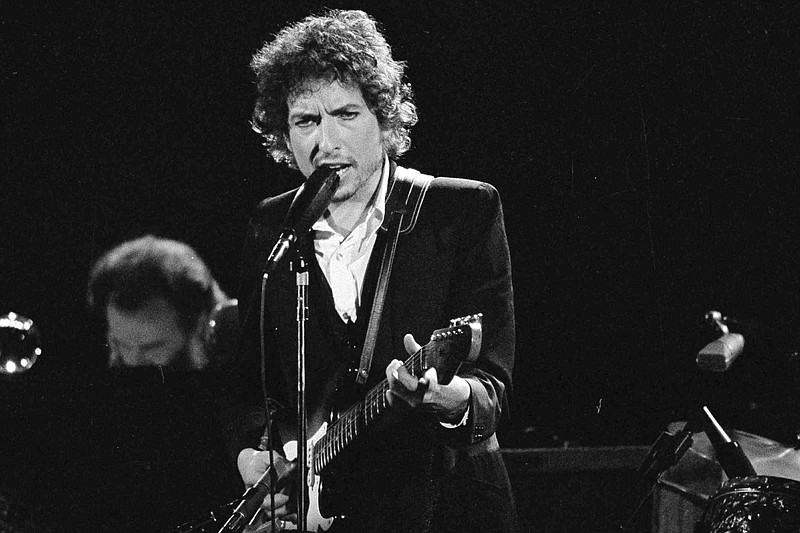 Musician Bob Dylan performs with The Band at the Forum in Los Angeles on Feb. 15, 1974. Transcripts of lost 1971 Dylan interviews with the late American blues artist Tony Glover and letters the two exchanged reveal that Dylan changed his name from Robert Zimmerman because he worried about anti-Semitism, and that he wrote "Lay Lady Lay" for actress Barbra Streisand. The items are among a trove of Dylan archives being auctioned in November 2020 by Boston-based R.R. Auction. (AP Photo/Jeff Robbins, File)