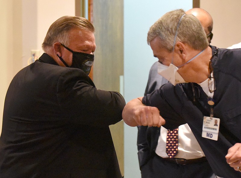 Staff Photo by Matt Hamilton /  Mayor Jim Coppinger, left, greets Dr. David Bruce with an elbow bump before the press conference Tuesday at the Hamilton County Health Department. Hamilton County Mayor Jim Coppinger renewed a mask mandate through Nov. 22 for the county on Tuesday, Oct. 6, 2020. 