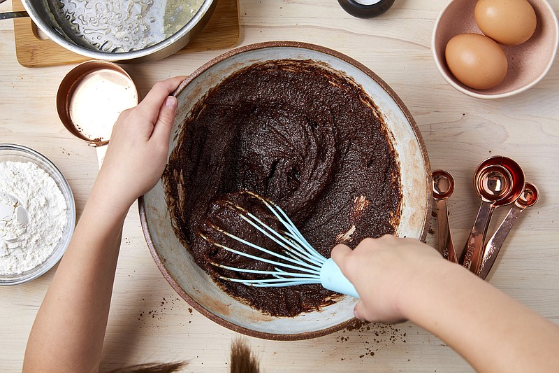 Whisking batter is a good Thanksgiving prep task for kids. A smaller, podded Thanksgiving celebration is an excellent time to lure your children into the kitchen and cook dinner as a family. / Photo by Lucy Schaeffer/The New York Times