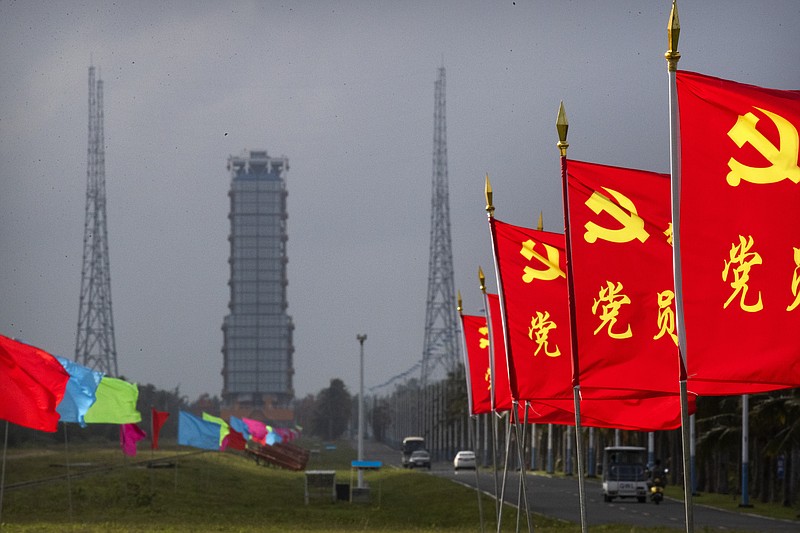 Flags with the logo of the Communist Party of China fly in the breeze near a launch pad at the Wenchang Space Launch Site in Wenchang in southern China's Hainan province, Monday, Nov. 23, 2020. Chinese technicians were making final preparations Monday for a mission to bring back material from the moon's surface for the first time in nearly half a century — an undertaking that could boost human understanding of the moon and of the solar system more generally. (AP Photo/Mark Schiefelbein)