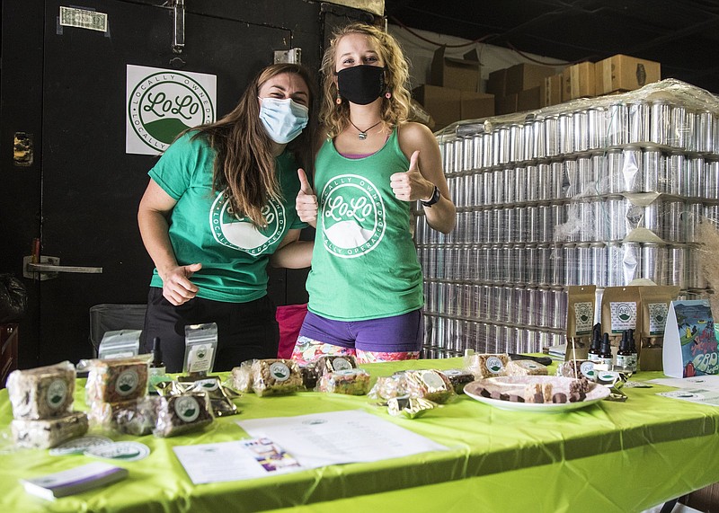 Staff photo by Troy Stolt / Erica Puzanov and Lolo Body Care owner Lauren Mindermann stand with their products during the Holiday Market at OddStory Brewing Company.