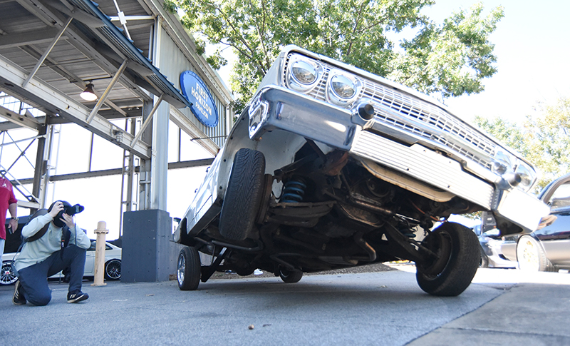 Staff photo by Matt Hamilton / Benjamin Konopka takes a picture of a vehicle on three wheels.