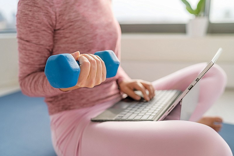 A woman works out in her home. / Getty Images