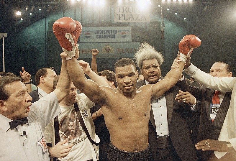 AP photo by Richard Drew / Heavyweight champion Mike Tyson's arms are raised in victory as fight promoter Don King, right, looks on after Tyson's first-round knockout of Michael Spinks on June 26, 1988, in Atlantic City, N.J. Tyson, who most recently fought in 2005, is returning to the ring in California this weekend for an exhibition against another retired boxing great, Roy Jones Jr.
