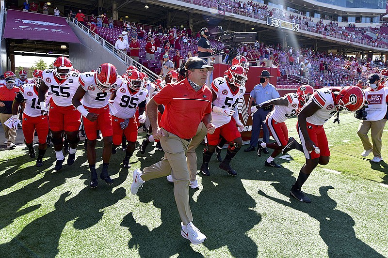 AP photo by Michael Woods / Georgia football coach Kirby Smart leads the Bulldogs onto the field before their season opener on Sept. 26 at Arkansas.